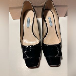Prada patent low heel squared heel pump.